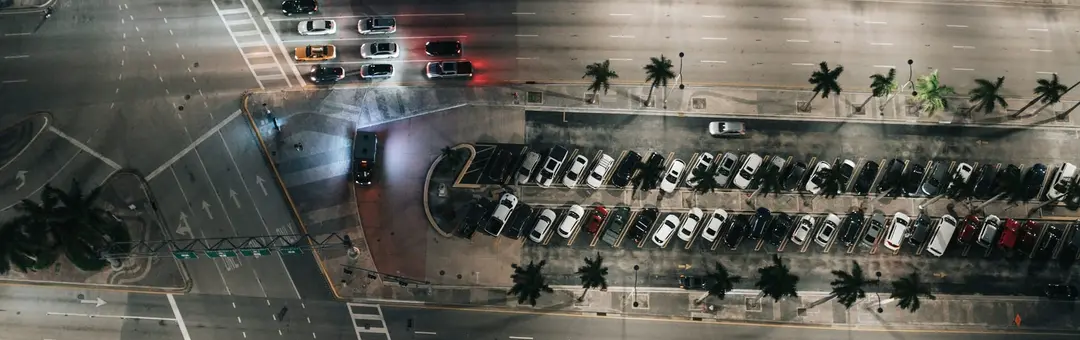 Aerial view of a parking lot and road at night from directly above