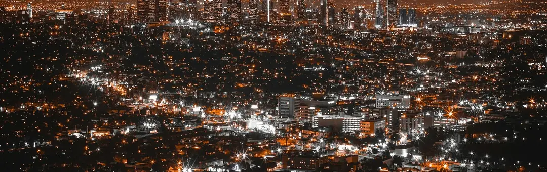 City lights spread across a valley at night, seen from above