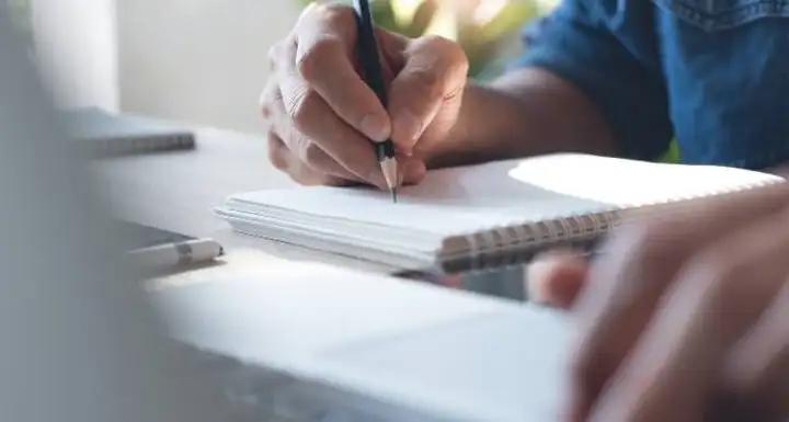 person writing in a notebook