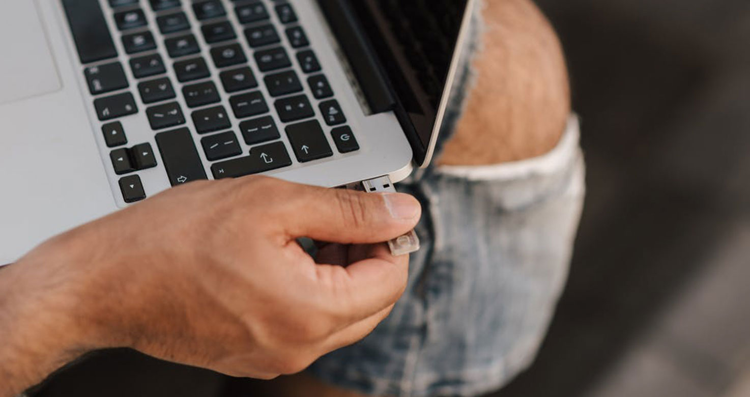 Worker inserting USB stick into port 